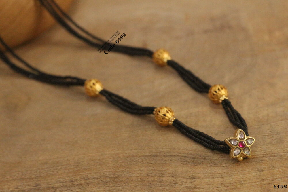 Black beads with jadaukundan pendant and gold balls