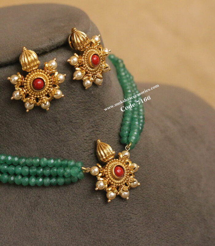 Antique gold pendant set with emerald beads