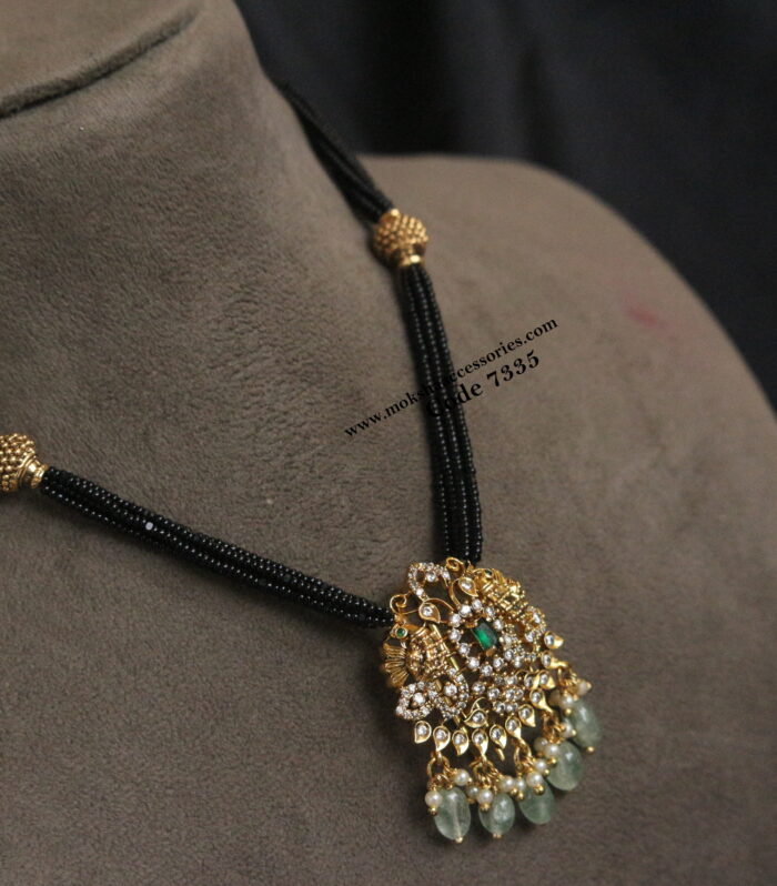 Gold pendant with emerald stone and black beads