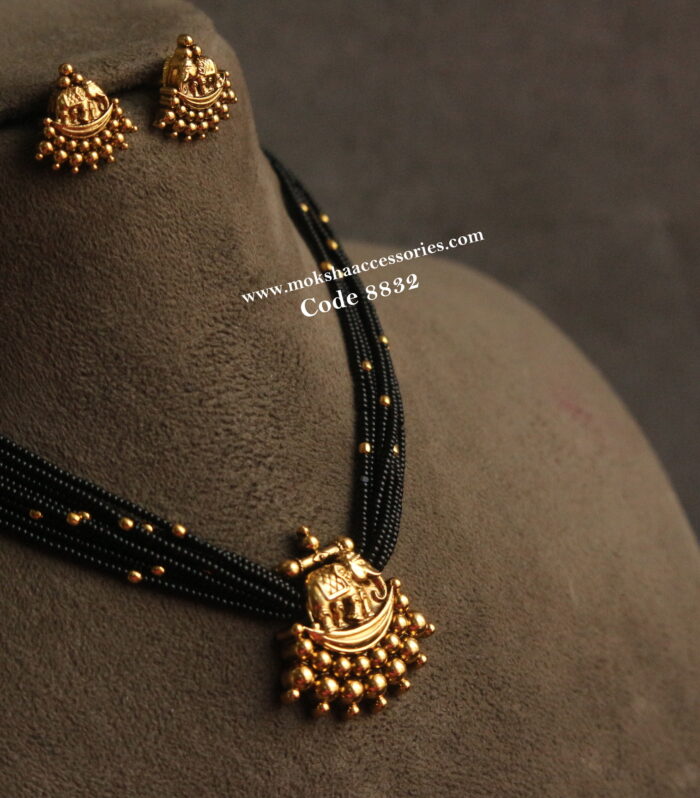 Antique gold pendant set with black beads and gold balls