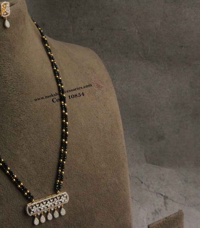 Diamond alike pendant set with black beads and gold balls