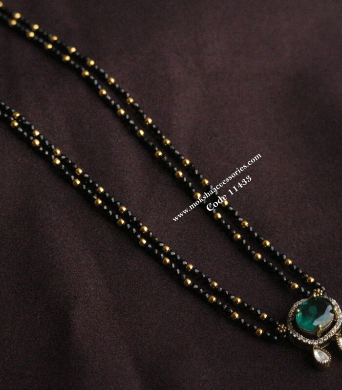 Emerald cz pendant with black beads and gold balls